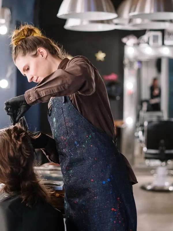 A stylist working with a client in a beauty salon